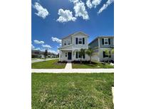 Two-story house with gray siding, blue door, and green lawn at 2893 Fitness St, Clermont, FL 34714