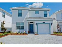 Two-story house with a two-car garage and landscaped front yard at 4839 Kings Castle Cir, Kissimmee, FL 34746