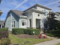 Two-story house with light-colored siding, landscaping, and a paved walkway at 2927 Windmill Dr, Kissimmee, FL 34741