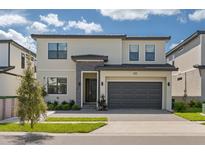 Two-story modern home with gray garage door and stone accents at 5773 High Seas Dr, Orlando, FL 32821