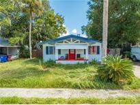 1920s bungalow with red door and overgrown yard at 1015 Ohio Ave, Saint Cloud, FL 34769