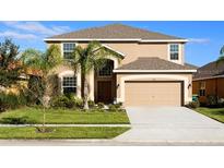 Two-story house with a large driveway and landscaping at 2505 Dharma Cir, Kissimmee, FL 34746