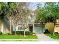 Two-story house with light teal exterior and landscaping at 8860 Candy Palm Rd, Kissimmee, FL 34747