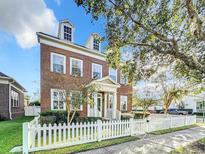 Brick home with white picket fence and dormer windows at 307 Norfolk St, Celebration, FL 34747
