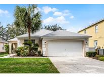 One-story house with a white garage door and landscaped yard at 8457 Secret Key Cv, Kissimmee, FL 34747