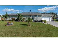 Ranch-style home with a well-maintained lawn, driveway, and garage at 1395 Emerald Dr, Kissimmee, FL 34744
