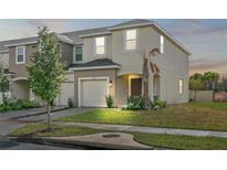 Two-story townhome with attached garage at dusk at 3550 Davenport Creek Ct, Kissimmee, FL 34746