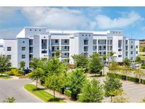 Building exterior, featuring a modern design, ample parking and landscaping at 4751 Clock Tower Dr # 107, Kissimmee, FL 34746