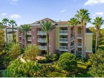Attractive condo building with lush landscaping and palm trees at 7662 Whisper Way # 402, Reunion, FL 34747