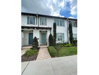 Modern townhouse with teal door and landscaping at 8919 Lakeshore Pointe Dr, Winter Garden, FL 34787