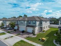 Two-story townhome with attached garage and manicured lawn at 15109 Willow Arbor Cir, Orlando, FL 32824