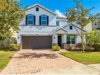 Two-story house with a brown garage door and landscaped front yard at 5249 Villa Rosa Ave, Saint Cloud, FL 34771