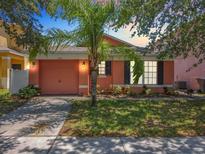 Charming single-story home with a peach-colored exterior and two-car garage at 270 Earlmont Pl, Davenport, FL 33896