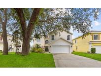 Two-story home with a large garage and landscaping at 632 Pinewood Dr, Davenport, FL 33896