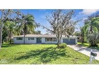 Newly renovated single story home with gray garage door and well-manicured lawn at 905 Valencia Rd, South Daytona, FL 32119