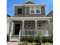 Two-story home with gray siding, white trim, and a front porch at 1608 Cross Prairie Pkwy, Kissimmee, FL 34744