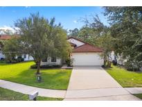 Single-story home with a red tile roof and attached garage at 9016 Murano Mews Ct, Kissimmee, FL 34747
