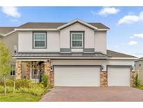 Two story home with three car garage and stone accents at 14442 Noto Ave, Clermont, FL 34714