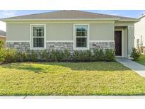 Single-story house with stone accents and landscaping at 6883 Botanic Blvd, Harmony, FL 34773