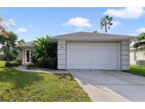 Single-story house with a white garage door and well-maintained lawn at 2904 Sunset Retreat Ct, Kissimmee, FL 34747