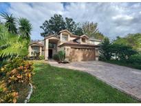 Two-story house with a brown garage door and landscaped yard at 325 Sonoma Valley Cir, Orlando, FL 32835