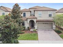 Two-story house with a brick driveway and landscaping at 9158 Wedge Dr, Davenport, FL 33896