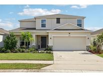 Two-story house with a two-car garage and landscaping at 4917 Vellacito Way, Davenport, FL 33897
