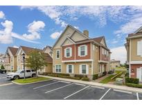 Two-story townhouse boasts attractive exterior with a landscaped walkway at 7585 Sunny Dreams Ln, Kissimmee, FL 34747