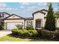 Single-story home with a two-car garage and landscaped yard at 7845 Wandering Way, Orlando, FL 32836