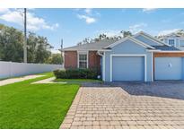 Front view of a light blue and brick home with a garage at 3401 Home Town Ln, St Cloud, FL 34769