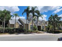A yellow two-story condo building with palm trees and landscaping at 1025 S Hiawassee Rd # 2216, Orlando, FL 32835