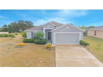One-story home with gray siding, attached garage, and landscaping at 2649 Sunset Cir, Lake Wales, FL 33898