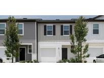 Two-story townhome with garage and landscaping at 437 Madison Dr, Davenport, FL 33837