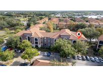 Aerial view of condo building with parking and landscaping at 6141 Metrowest Blvd # 307, Orlando, FL 32835