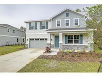 Two-story house with gray siding, teal shutters, and stone accents at 680 Summit River Dr, Apopka, FL 32712