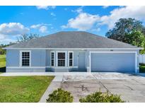 Newly built home with gray exterior, two-car garage, and well-maintained lawn at 905 Gascony Ct, Kissimmee, FL 34759