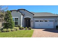 Attractive single-story home with gray siding, a two-car garage, and a brick driveway at 2914 Scarlett Dr, Saint Cloud, FL 34772