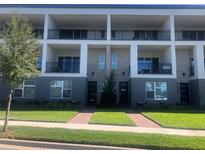 Modern three-story townhouses with private balconies and landscaped lawn at 9778 Bucklow Hill Dr, Orlando, FL 32832