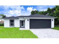 Newly built home with a two-car garage and landscaped lawn at 1030 Darlington Ct, Kissimmee, FL 34758