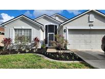 Single-story home with gray exterior, two-car garage, and well-manicured landscaping at 1270 Ballyshannon Pkwy., Orlando, FL 32828