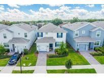 Aerial view of two-story townhouses with gray roofs and landscaped yards at 1648 Moon Valley, Davenport, FL 33896