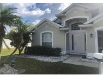 House exterior featuring a well-maintained lawn and a neutral color palette at 2303 Walnut Canyon Dr, Kissimmee, FL 34758
