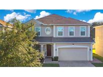Two-story house with a brown roof, attached garage, and landscaping at 2811 Sonata Ct, St Cloud, FL 34772