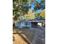 Newly renovated home with gray siding, landscaping, and a carport at 5413 Vanderlin St, Orlando, FL 32810