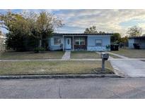 Cute bungalow style home with a well-maintained lawn and updated exterior at 7024 Moderna Way, Orlando, FL 32822