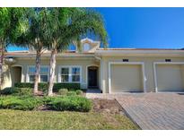 Exterior view of a two-story house with a two-car garage and well-manicured landscaping at 1125 Trappers Trail Loop, Davenport, FL 33896