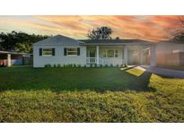 Charming bungalow with a newly renovated exterior, featuring a landscaped lawn and driveway at 527 Sunrise Dr, Orlando, FL 32803