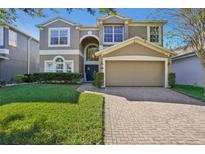 Two-story house with a large front yard, driveway, and attached garage at 9026 Dry Creek Ln, Orlando, FL 32832