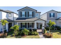 Two-story house with gray siding, landscaping, and a walkway at 12749 Brodlove Lane, Winter Garden, FL 34787