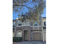 Two-story townhome with stone and beige exterior at 2018 Gold Spring Cv, Kissimmee, FL 34743